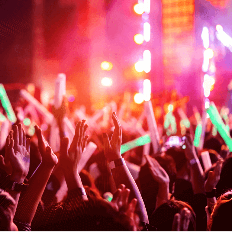 The raised hands of a large crowd of people at a live concert event.